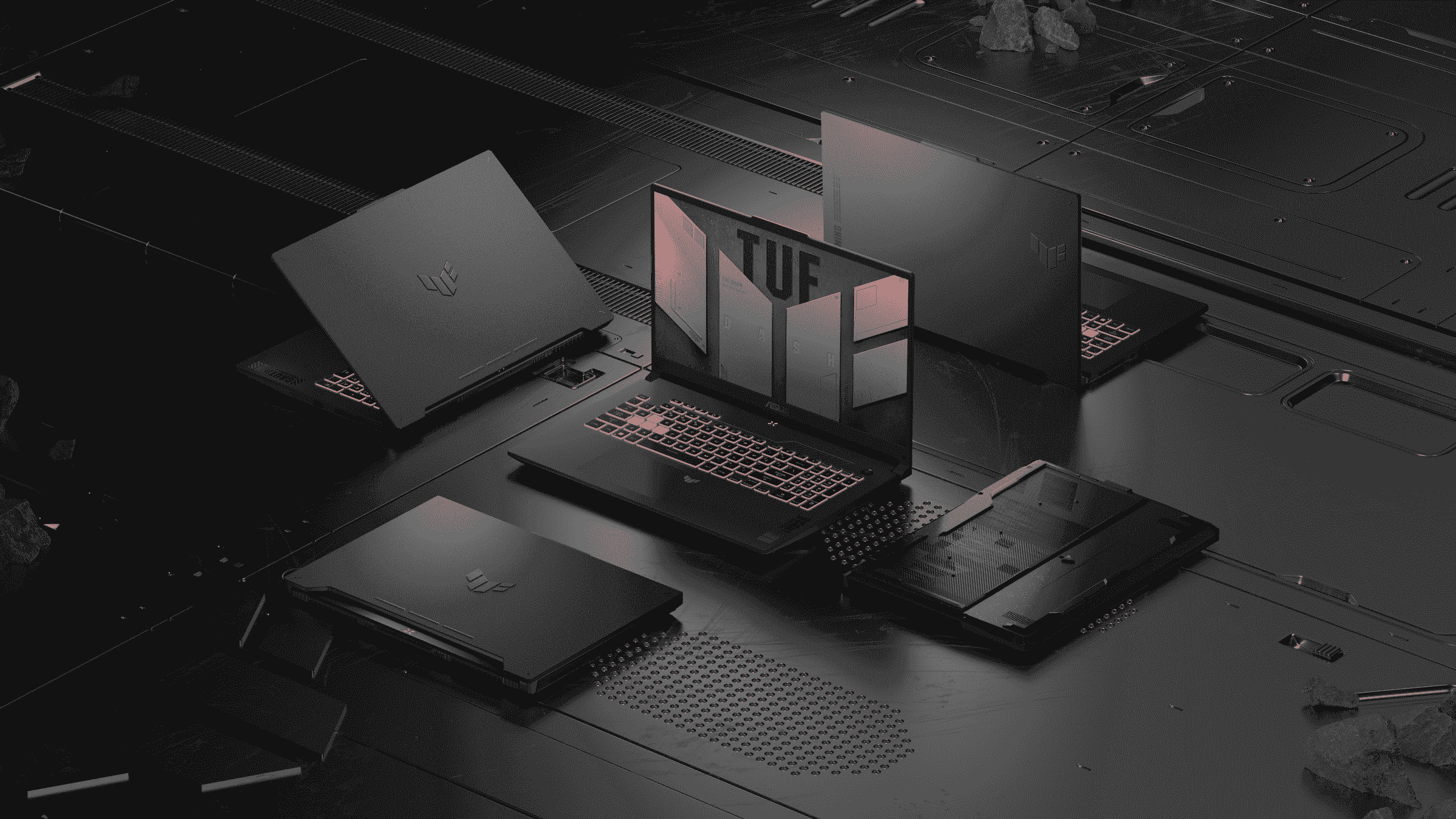 Siyah bir masa üzerinde ızgara şeklinde düzenlenmiş beş Asus TUF dizüstü bilgisayar.