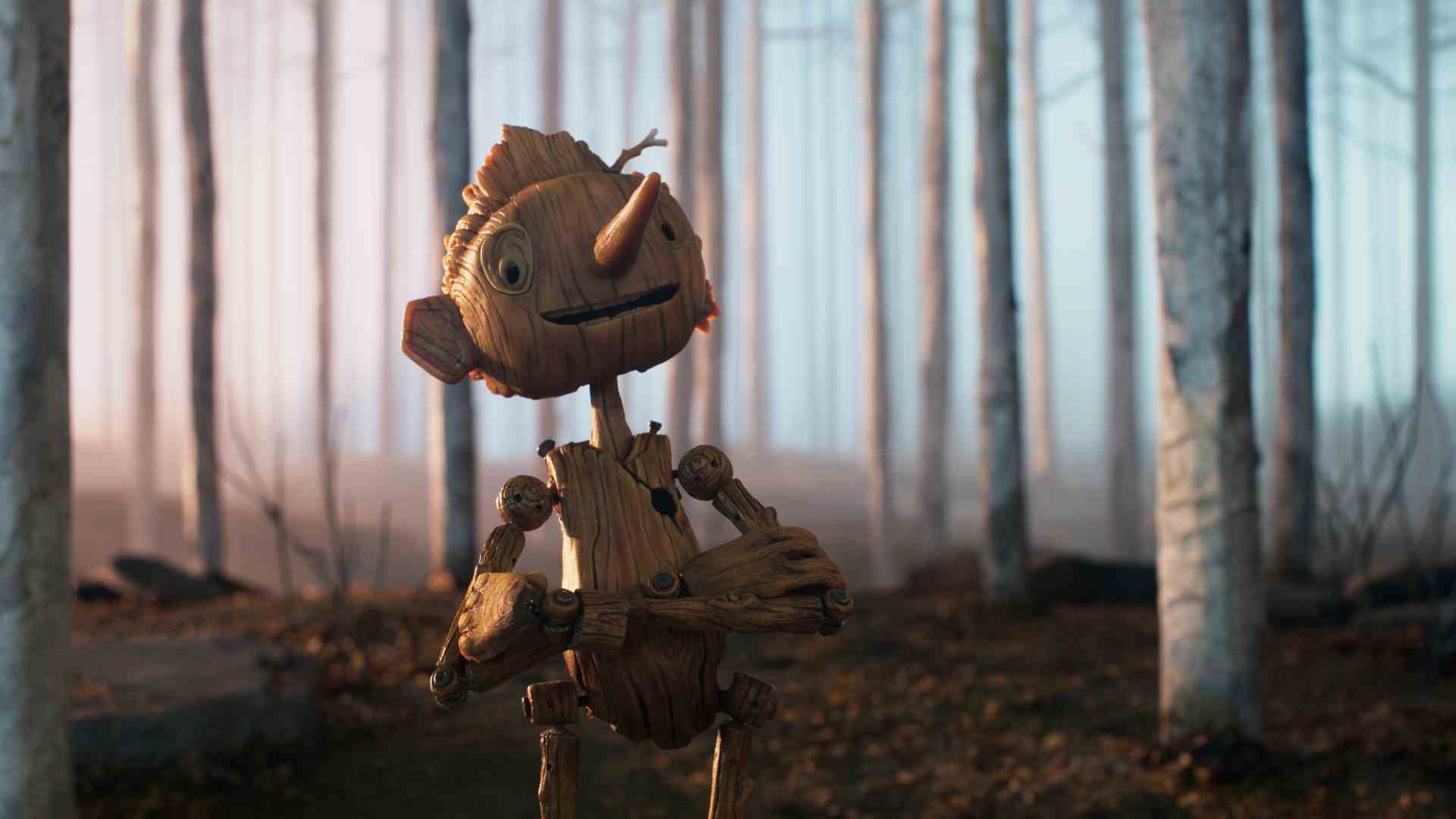 Guillermo del Toro'nun Netflix için stop-motion film uyarlamasında Pinokyo bir ormanda kollarını kavuştururken gülümsüyor