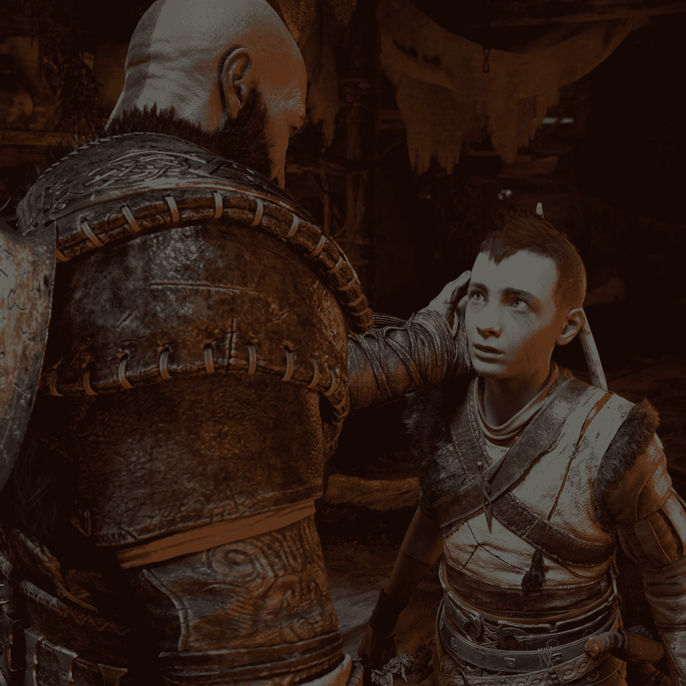 Kratos'un ergenlik çağındaki oğlu Atreus'un yüzüne nazikçe dokunduğu God of War Ragnarök'ten ekran görüntüsü