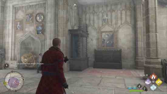 Hogwarts Legacy Daedalian anahtarları - kırmızı cüppeli Hufflepuff öğrencisi asasını çıkarmış ayakta duruyor.  Yaşlı bir keşiş portresinin yanında duran uçan bir anahtara ve içinde amblem bulunan ahşap bir dolaba bakıyor.  Tablolar ve altın küre de yakınlardadır.