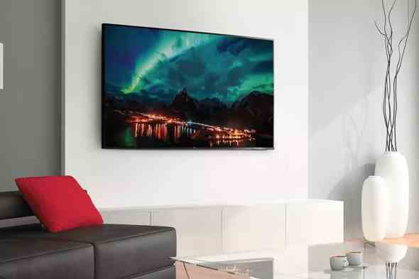Bir oturma odası duvarına monte edilmiş TCL 65 inç Sınıf 4 Serisi 4K TV ve ekranda Kuzey Işıkları görüntüsü.