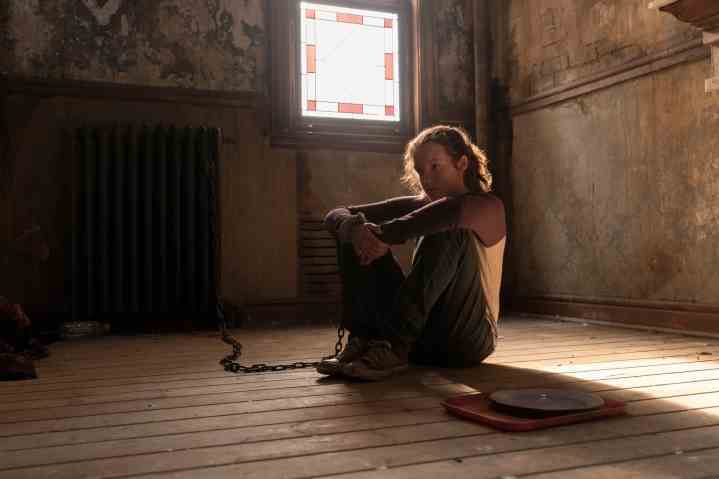 Ellie, The Last of Us Episode 1'de bir fırına zincirlenmiş olarak oturuyor.
