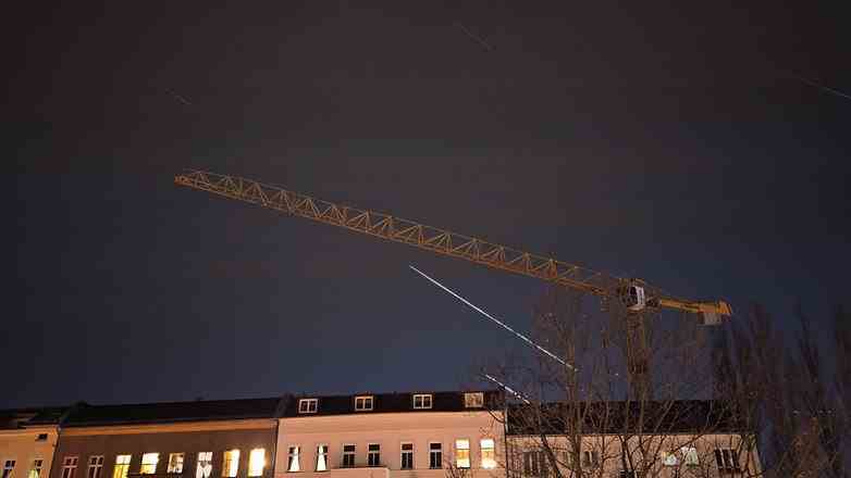 Berlin gece gökyüzünde bir evin üzerinde yıldız izi
