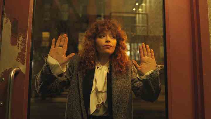 Natasha Lyonne, Russian Doll'da Nadya rolünde, yüzü bir metro kapısına dayalı.