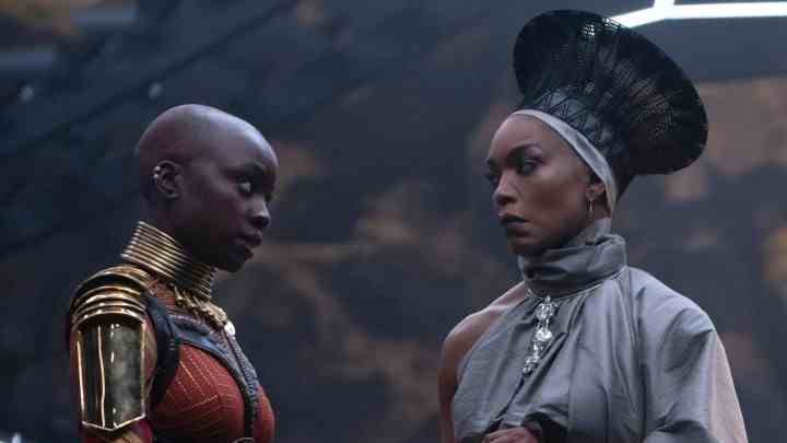 Danai Gurira ve Angela Bassett, Black Panther: Wakanda Forever'dan bir sahnede dikkatle birbirlerine bakıyorlar.