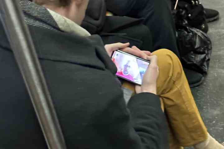 Bir metroda Google Pixel Fold olduğu iddia edilen bir akıllı telefon tutan biri.