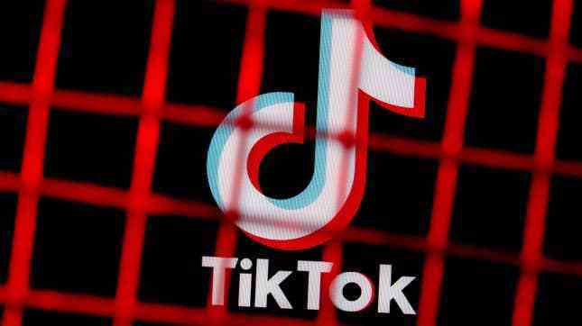 TikTok logosunun kırmızı bir çitin arkasındaki görüntüsü.  Biden yönetimi, Çinli paydaşların uygulamadaki sahipliklerini elden çıkarmalarını talep ediyor.