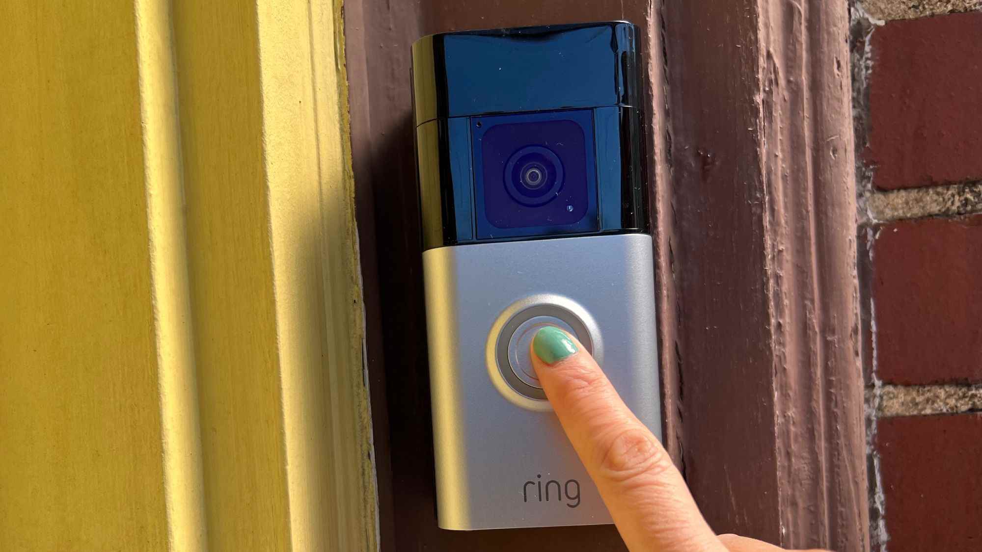 Bir parmak Ring Battery Doorbell Plus üzerindeki düğmeye basar