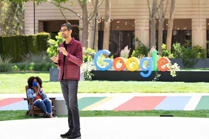 Sundar Pichai, Google I/O 2021'de bir Google logosunun önünde duruyor.