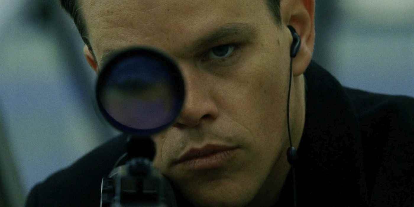 Jason Bourne bir keskin nişancı tüfeği dürbününe bakıyor