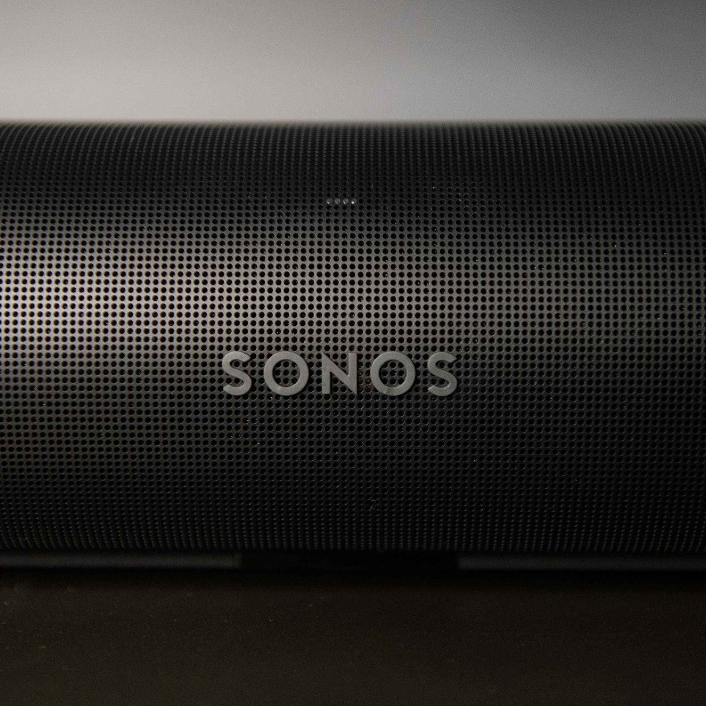 Sonos logosunu ve dış kasadaki birçok delikli deliği gösteren, Sonos Arc'ın ön kısmının ayrıntılı bir görüntüsü.