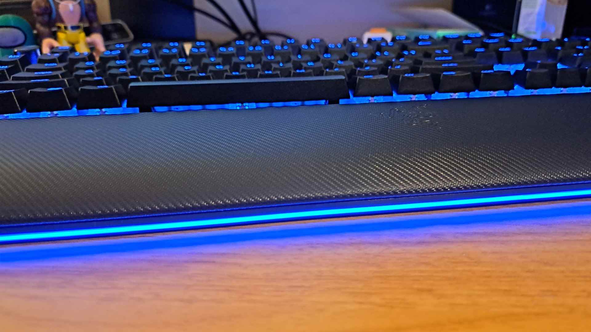 Razer BlackWidow V4 Pro incelemesi: Hem tuş başlıklarında hem de bilek desteğinde RGB aydınlatmasını gösteren geniş bir klavye görünümü