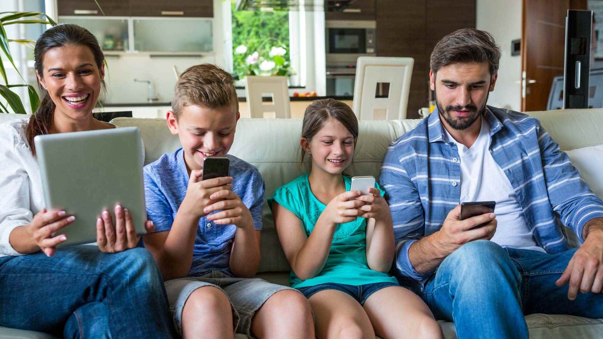 İnternete bağlı cihazları kullanan mutlu bir aile