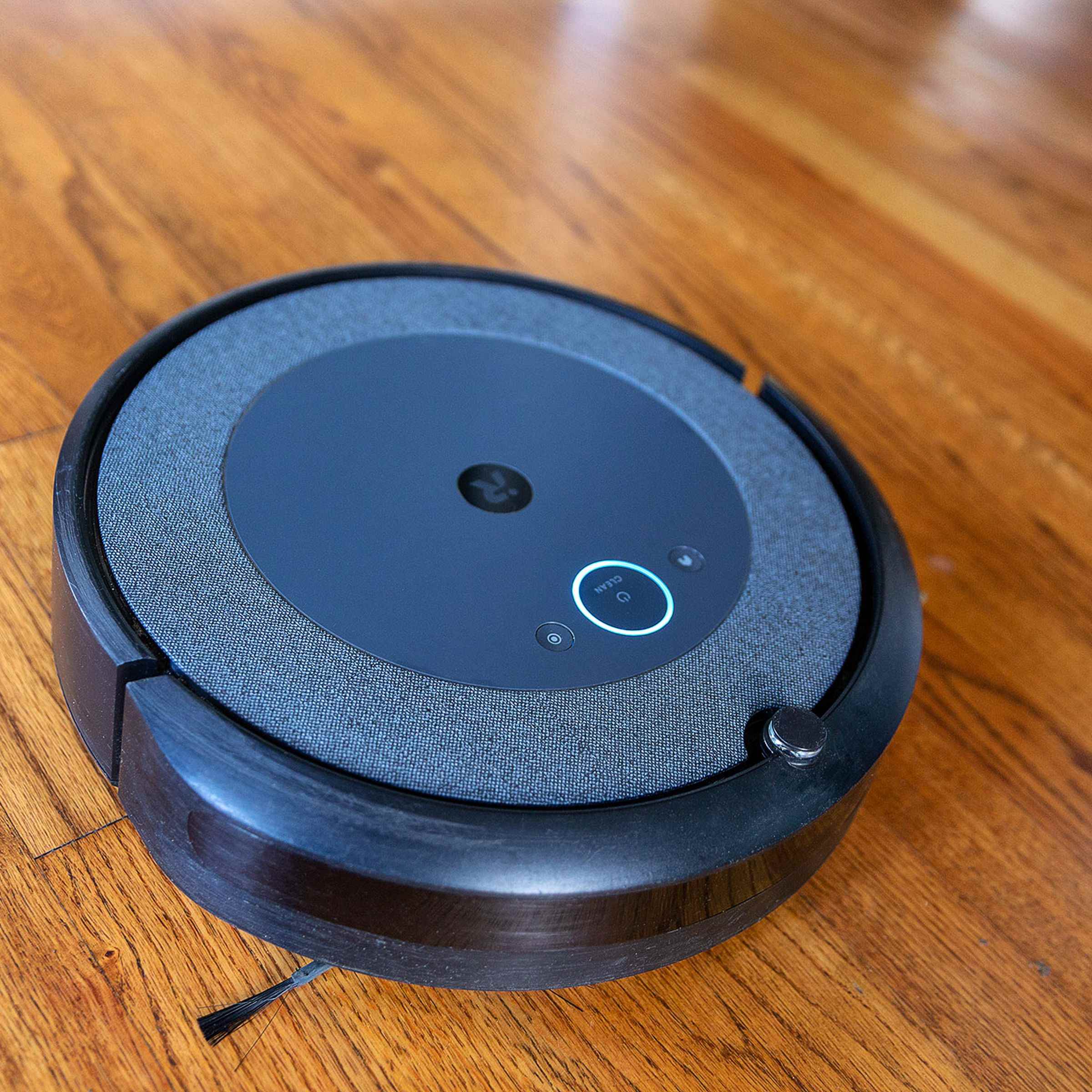 Ahşap zemin üzerinde duran iRobot Roomba i3 Plus EVO robot süpürgesi.