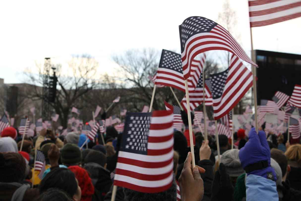 Amerikalılar Birleşik Devletler bayraklarını sallıyor.