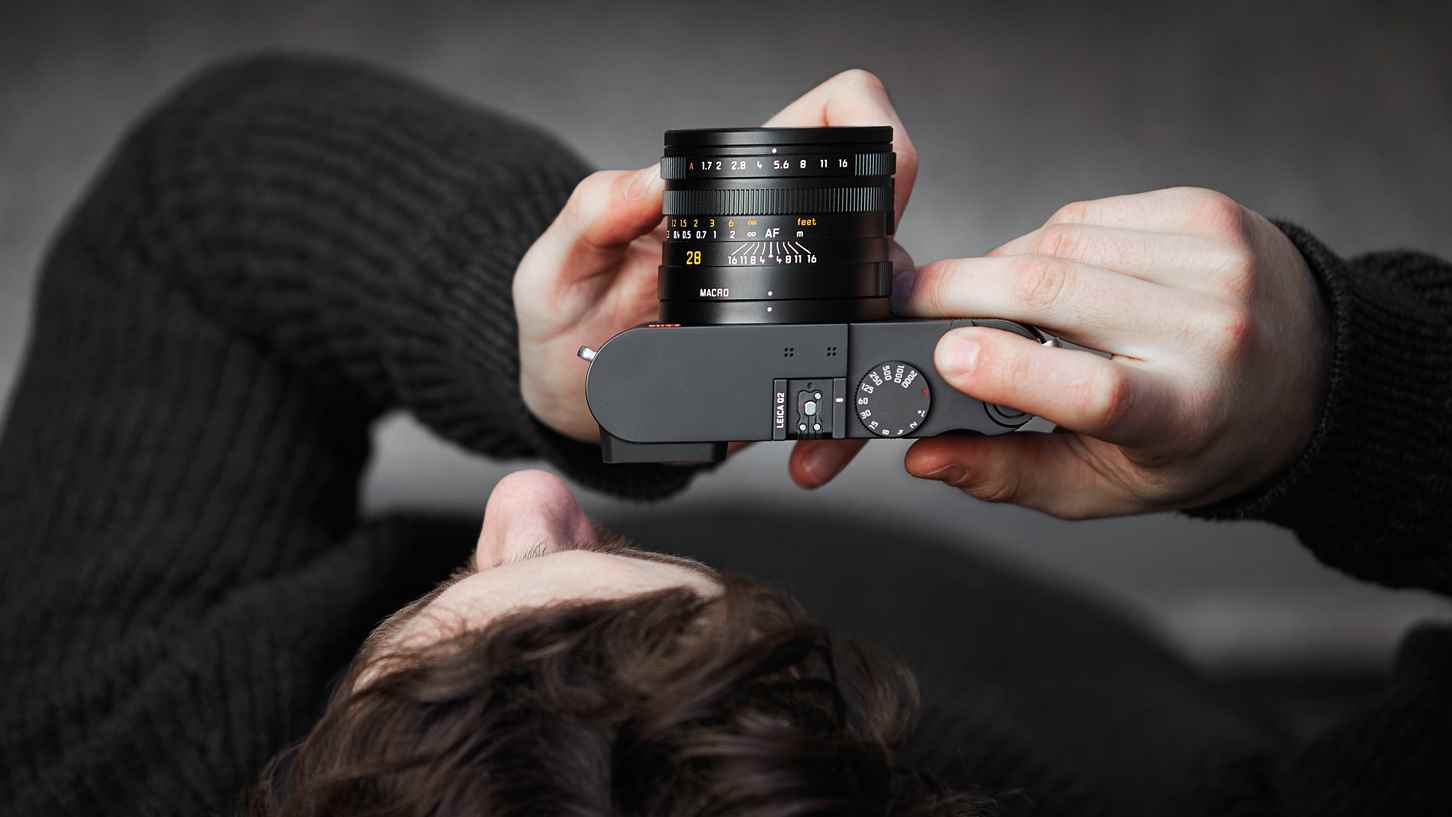 Leica Q2 kamerayı yüzüne tutan bir adam
