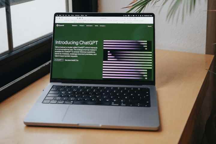 Ekranında ChatGPT'nin web sitesinin gösterildiği bir masa üzerindeki MacBook Pro.