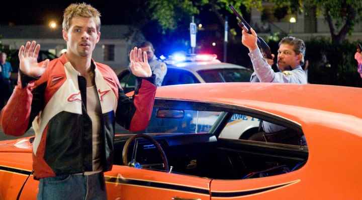 James Marsden, Sex Drive'da bir polis ona silah doğrulturken ellerini kaldırıyor.