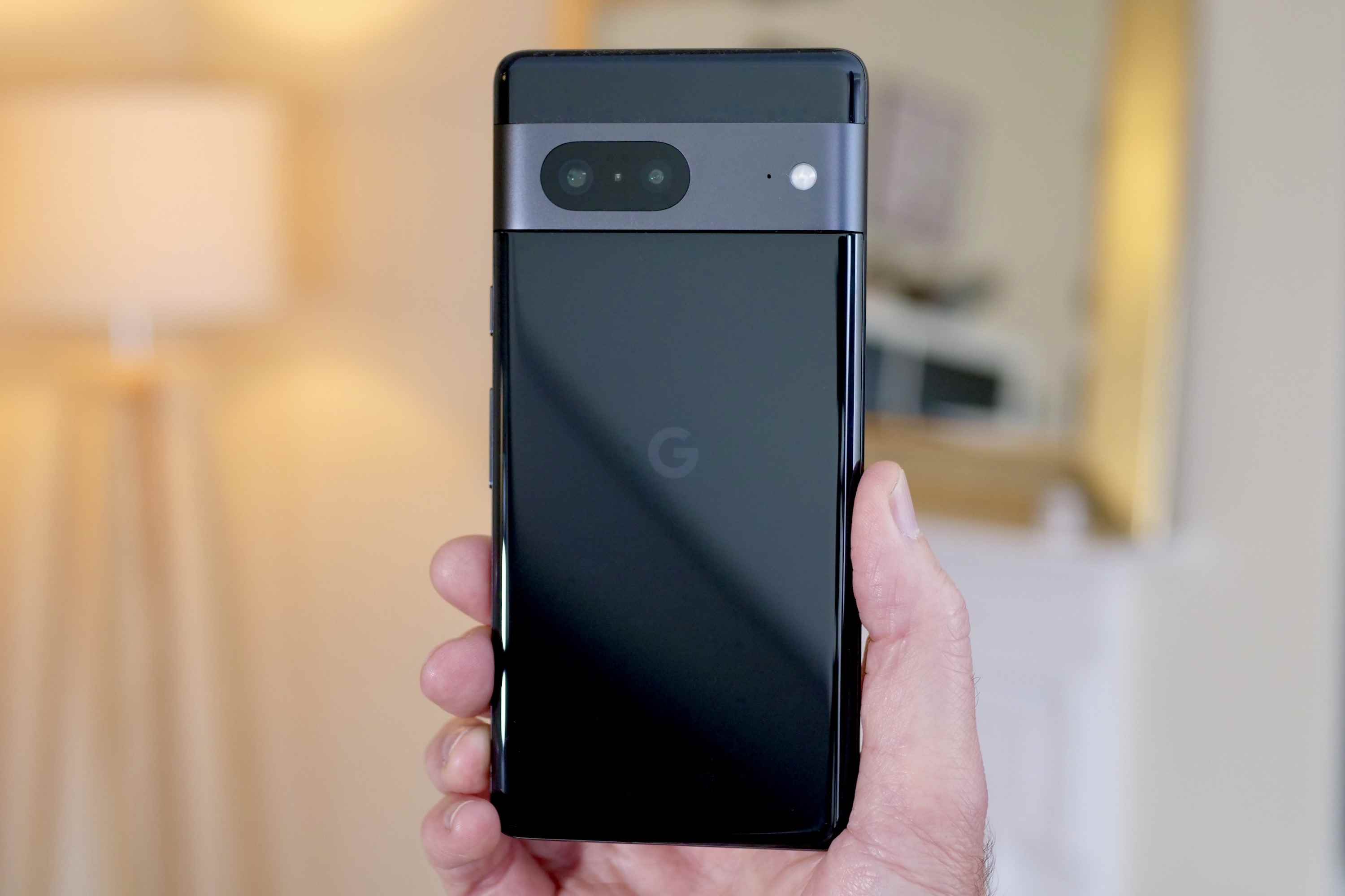 Bir adamın elinde tutulan Google Pixel 7'nin arkası.