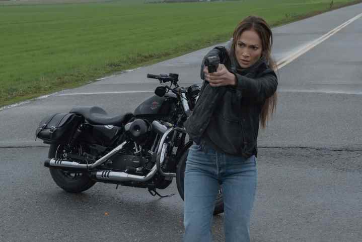 Jennifer Lopez, The Mother'da motosikletinin önündeyken silah doğrultuyor.