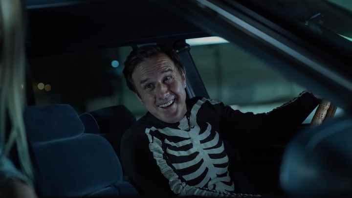 David Arquette, Mrs.  Davis, iskelet bir gömlek giymiş bir arabada oturuyor.