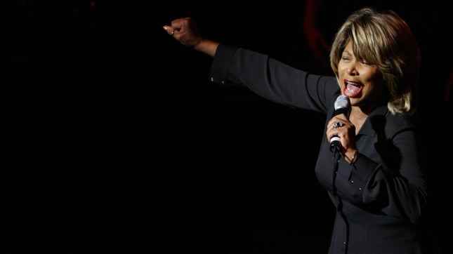 Tina Turner sahnede mikrofona şarkı söylüyor