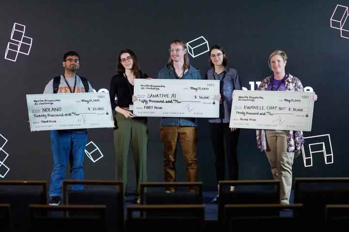 Mozilla'nın 2023 Sorumlu Yapay Zeka Yarışmasının kazananları ödül çeklerini tutarak bir sahnede duruyor.