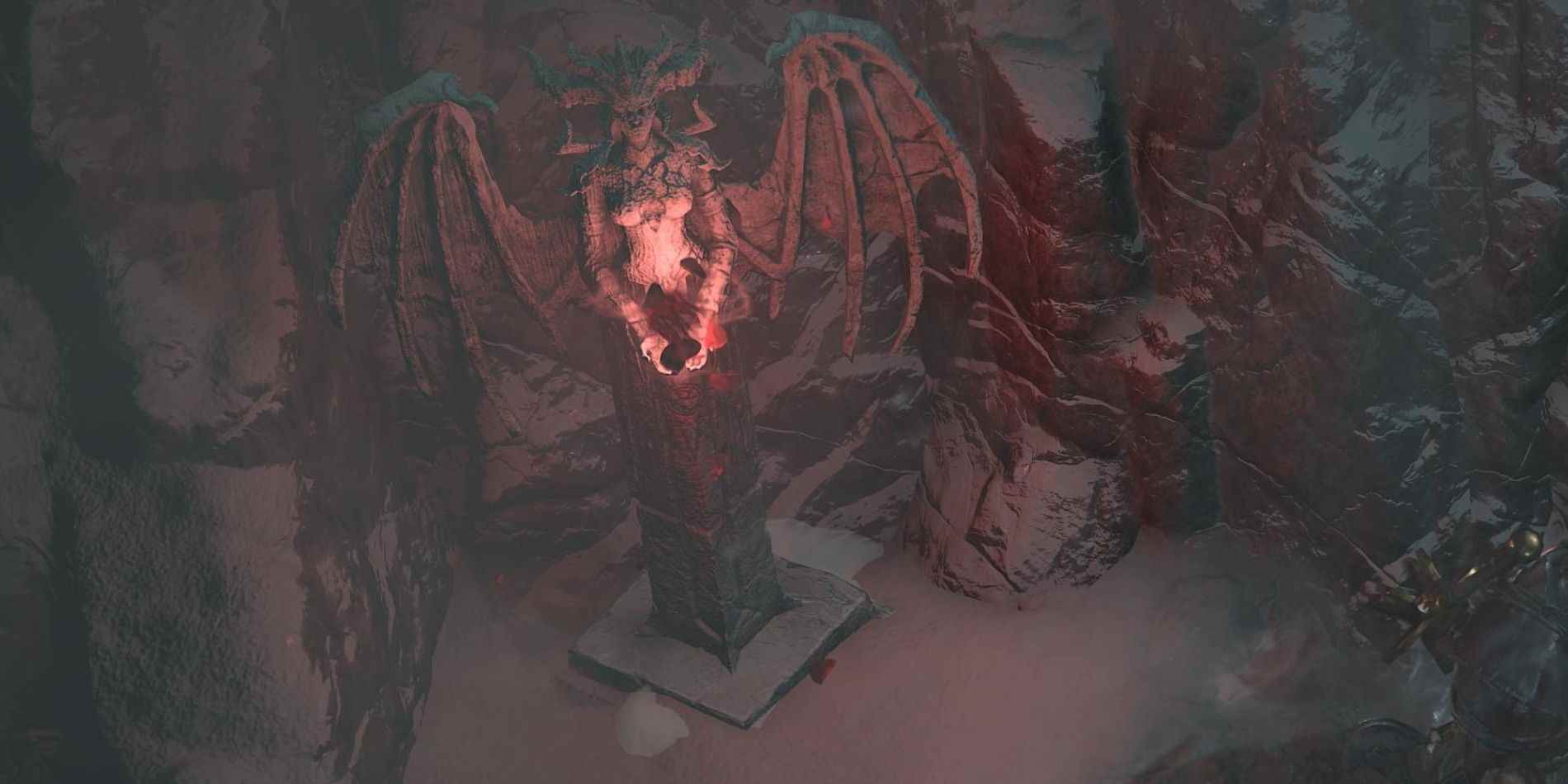 Boynuzlu ve kanatlı düşman Lilith'in kayalık, karlı bir oyukta kırmızı renkte parıldayan bir heykeli.