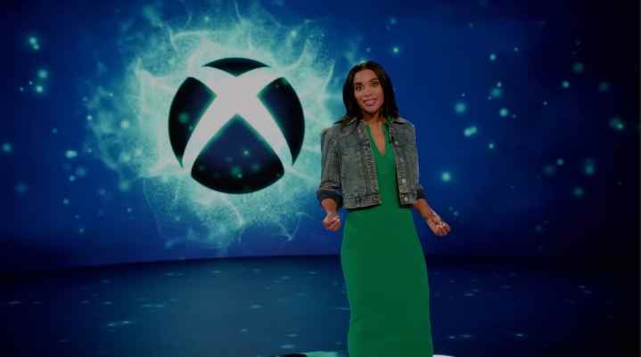 Sarah Bond, Xbox Games Showcase sırasında bir Xbox logosunun yanında duruyor.