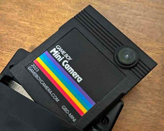 Game Boy Mini Kamera kartuşu, bir Game Boy el cihazına yarı yerleştirilmiş.