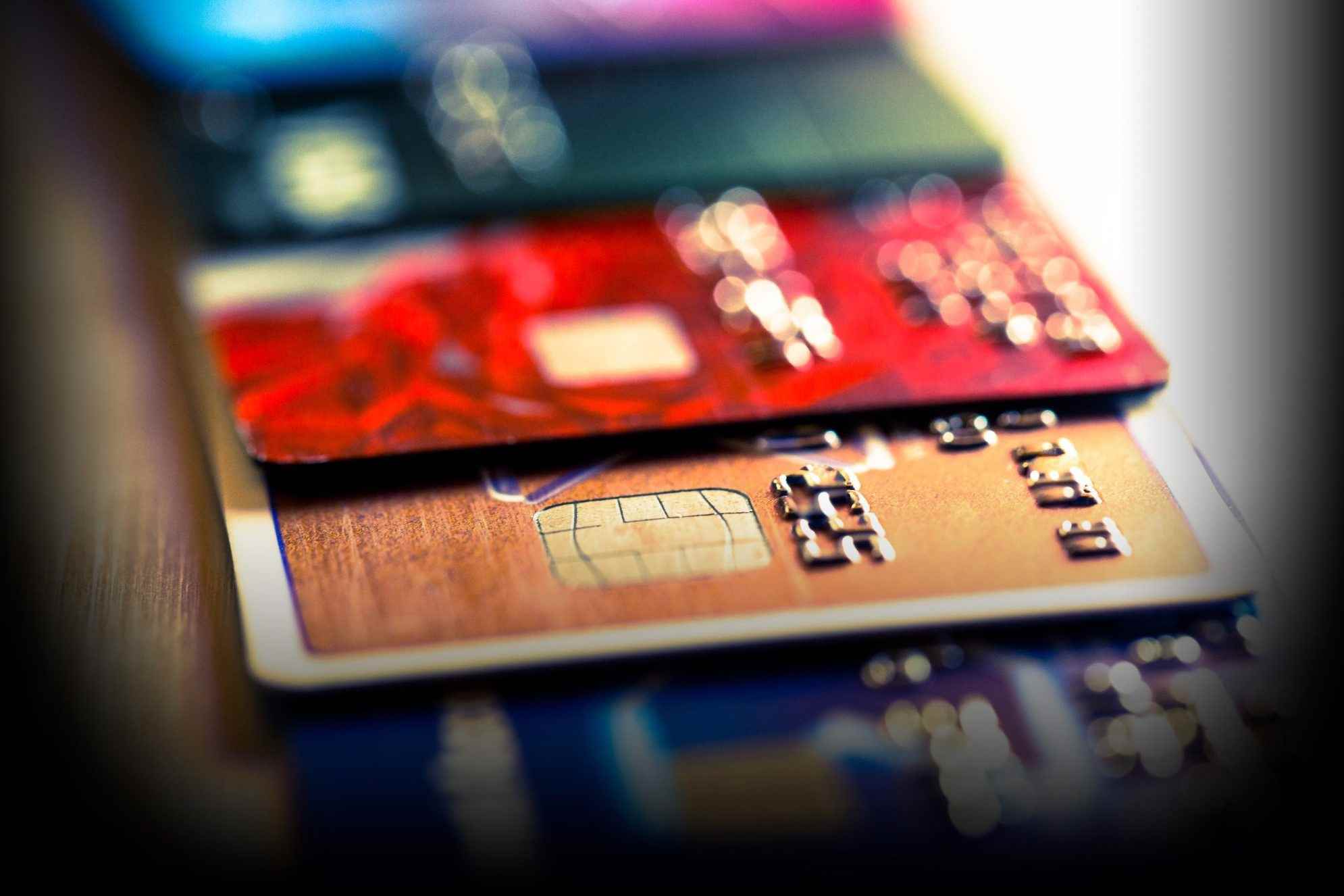 Banka ve kredi kartları ve sayısal rakamlardan oluşan bir koleksiyonun soyut bir görünümünü gösteren makro renkli görüntüyü kapatın.