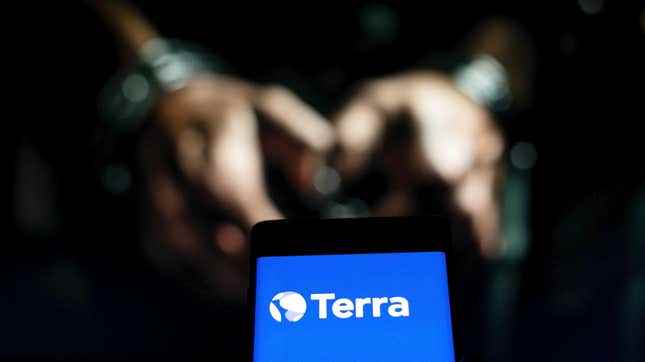 Kelepçeli kişinin önünde Terra logosu.  Terraform Labs kurucu ortağı Do Kwon'un Karadağ'da tutuklandığı bildirildi.  Borsada TerraUSD kripto para birimi hisselerinin çöküşü.