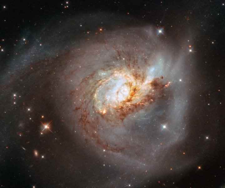 Tuhaf gökada NGC 3256, NASA/ESA Hubble Uzay Teleskobu'ndan alınan bu görüntünün merkezinde yer alıyor.  Bu çarpık gökada, muhtemelen 500 milyon yıl önce meydana gelen iki sarmal gökada arasındaki kafa kafaya çarpışmanın enkazıdır ve iki gökadanın gaz ve tozunun çarpışmasıyla oluşan genç yıldız kümeleriyle süslenmiştir.