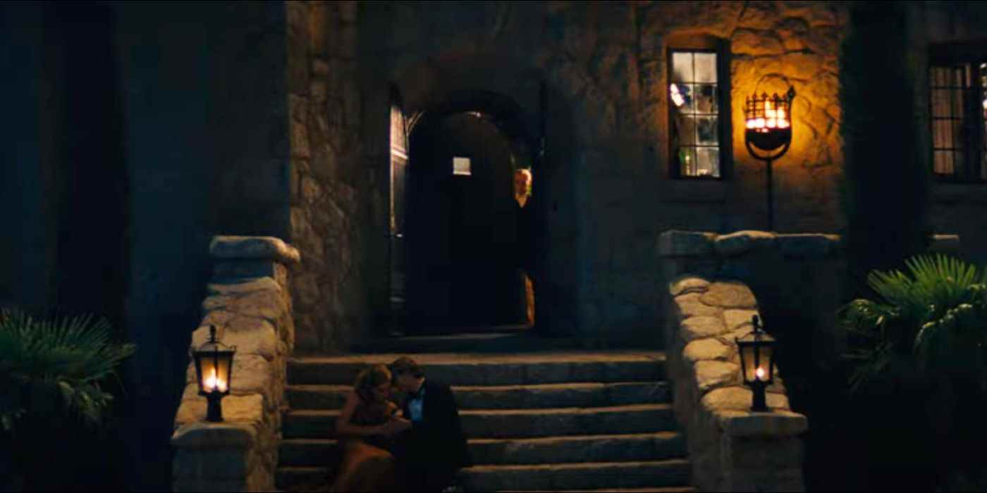 Partinin ön kapısından bir adam çıkar ve iki kişi merdivenlerde öpüşür.