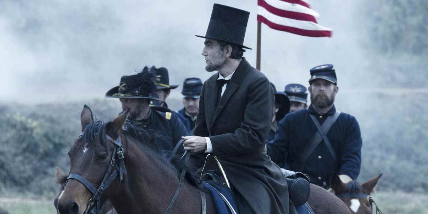 Daniel Day Lewis , ünlü siyah ceketi ve soba borusu şapkasıyla Abraham Lincoln rolünde bir atın üzerinde oturuyor, ardından Birlik Ordusu üniformalı atlı askerler bir direğin tepesinde bir Amerikan bayrağı taşıyor