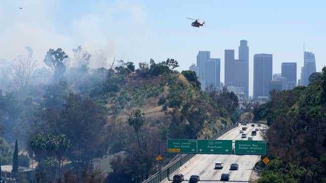 Bir Los Angeles Şehri İtfaiye Departmanı helikopteri, 7 Temmuz 2023'te Los Angeles'ta Elysian Park bölgesinde çıkan bir çalı yangınına su damlatmaya hazırlanıyor.