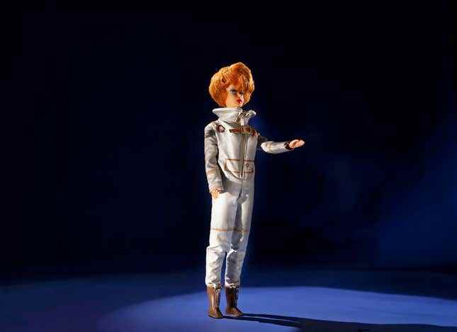 Bayan Astronot kıyafeti giymiş bir Barbie bebek.