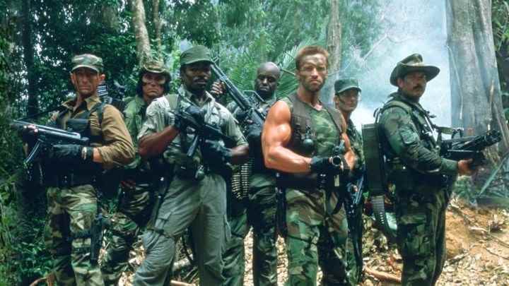 Predator ekibi ormanda silahlarıyla poz veriyor.